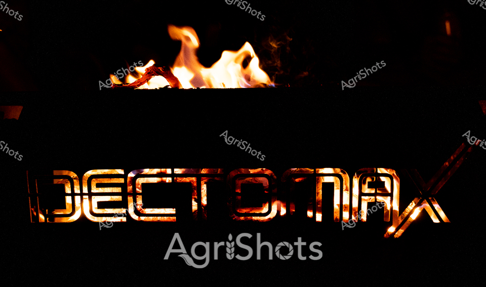 Flames leap and dance against the midnight backdrop, illuminating the bold "DECTOMAX" branding with a fierce, golden-orange glow. The fiery typography transforms the agricultural pharmaceutical logo into a dramatic visual statement, resonating with the intensity of outback veterinary care. Each letter burns with a raw, elemental energy, suggesting the potent strength of livestock medication in harsh Western Australian conditions. The high-contrast design speaks to the rugged precision required in remote station management, where animal health treatments must be as robust as the landscape itself. The burning text becomes a metaphorical representation of agricultural innovation - bright, powerful, and transformative against the dark wilderness of the station environment.