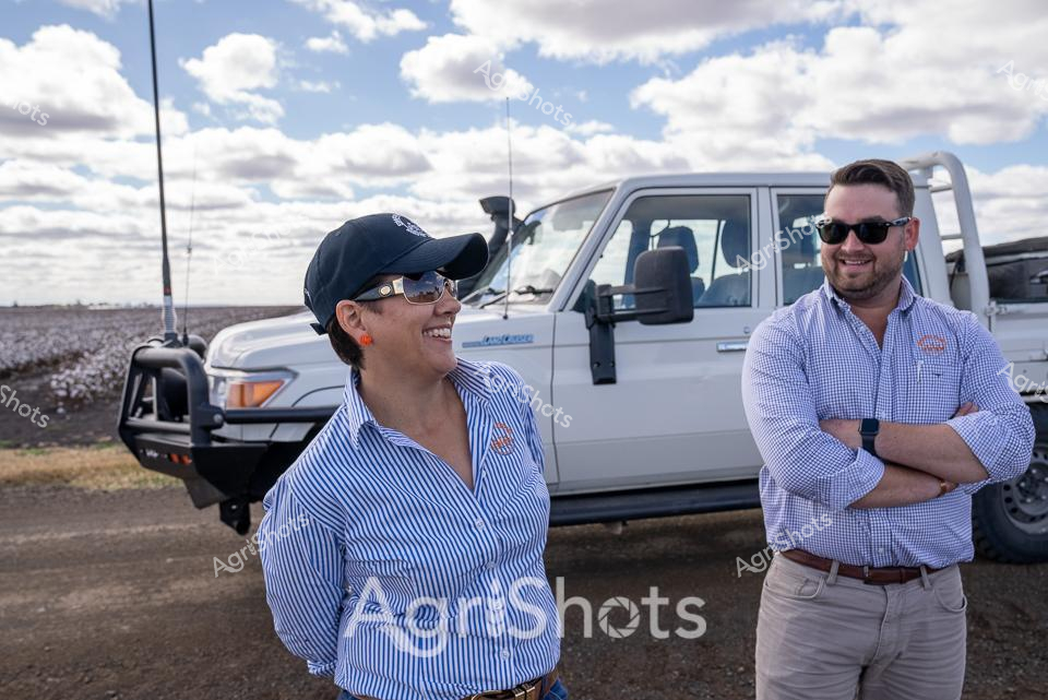 Cotton Country Collaboration

Brilliant white cotton fields stretch beneath a billowing cloudscape, framing two agricultural professionals standing beside a rugged Toyota Land Cruiser. A woman in a crisp blue and white striped button-up shirt and baseball cap shares a warm laugh with her colleague, a man in a gingham check shirt and sunglasses. Their relaxed body language and professional attire suggest a deep understanding of the agricultural landscape surrounding them - the vast cotton fields of Queensland ready for harvest.

The gleaming white four-wheel drive, fitted with robust bull bars, speaks to the demanding terrain of rural Australia. Dusty ground and an expansive sky create a quintessential rural backdrop, capturing the resilience and camaraderie of modern agricultural workers. Their matching branded shirts and confident postures reflect the technical expertise and collaborative spirit required in contemporary cotton production.

The scene embodies the intersection of technology, skill, and natural environment that defines Australian agricultural excellence - a moment of connection amid the wide-open potential of the crop lands.