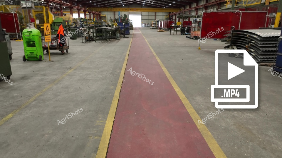 Industrial pathway through precision manufacturing sanctuary. Crimson safety walkway bisects a meticulously organized industrial environment, delineated by crisp yellow boundary lines amid gleaming concrete flooring. Lime-green industrial equipment and strategic warning signage punctuate the expansive production space, suggesting rigorous workplace safety protocols. Robust red protective screens and stacked metal components frame the central corridor, revealing a sophisticated manufacturing ecosystem designed for efficiency and controlled movement. Overhead structural beams and sophisticated machinery populate the background, creating a cathedral-like atmosphere of industrial craftsmanship. The stark, deliberate color palette - from safety green to warning red - communicates a language of workplace discipline and systematic organization, quintessential to advanced Australian manufacturing environments.